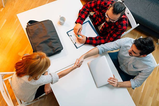 Young woman at a job interview talking with two developers. They are running startup developer company from their home. Top view.